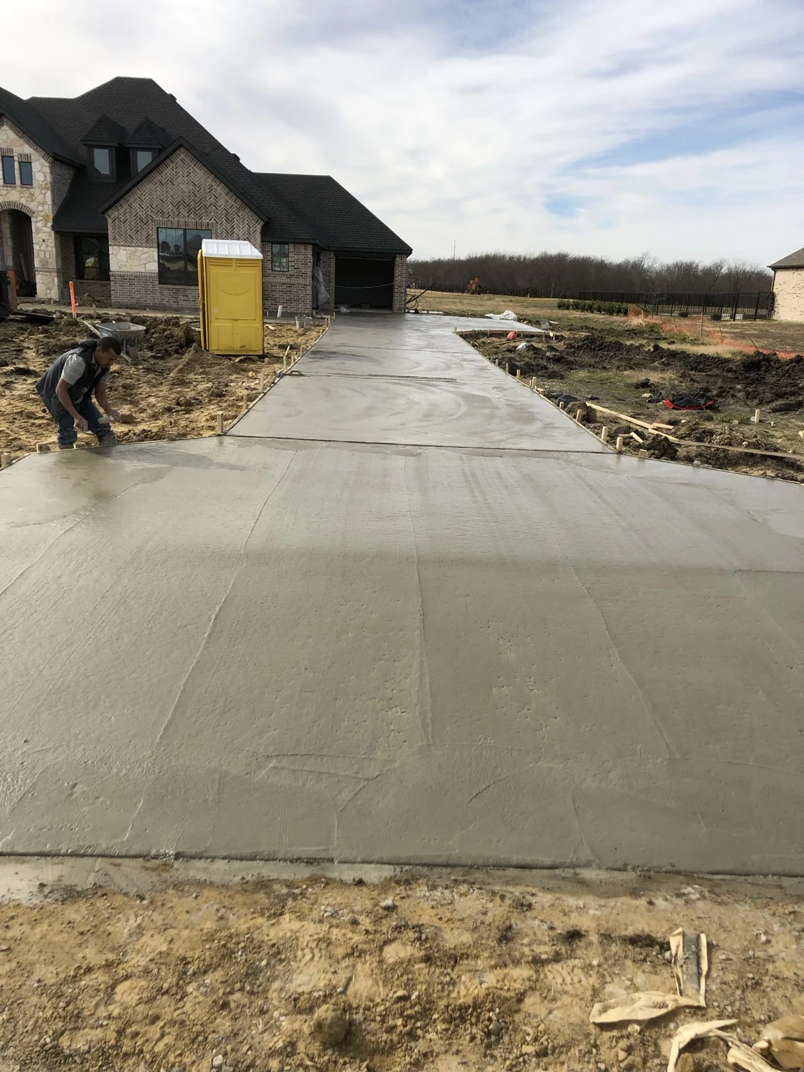 Newly placed concrete driveway leading to a residential garage